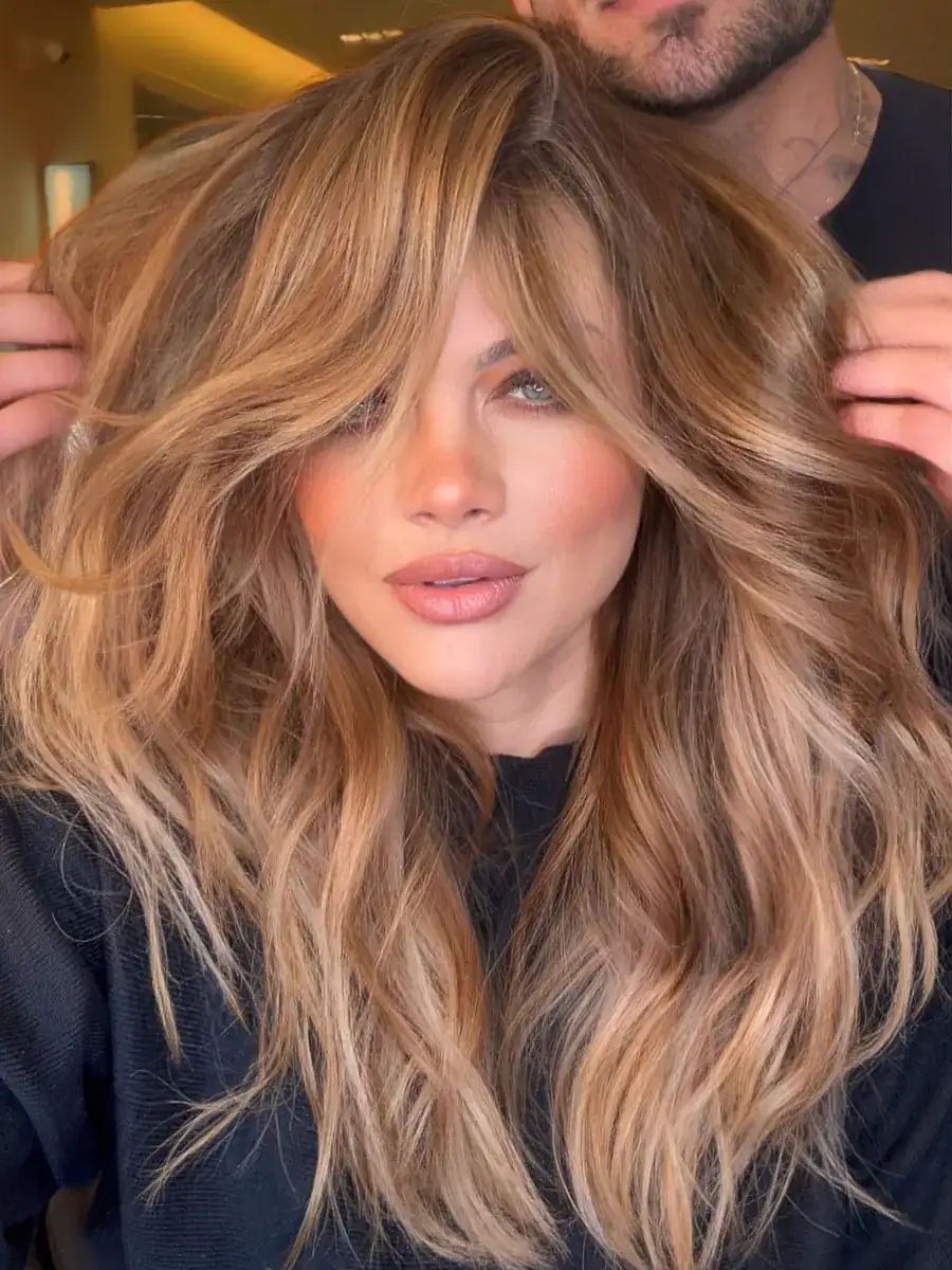 Cliente com mechas douradas e franja, Neto ajeitando o cabelo